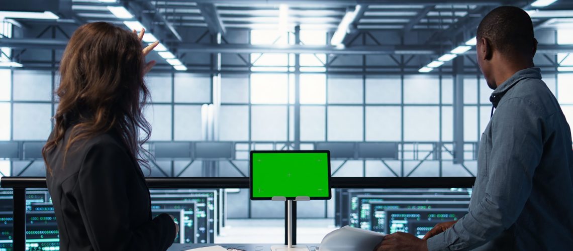 engineers-overseeing-server-room-with-mockup-device-reading-documentation (1)